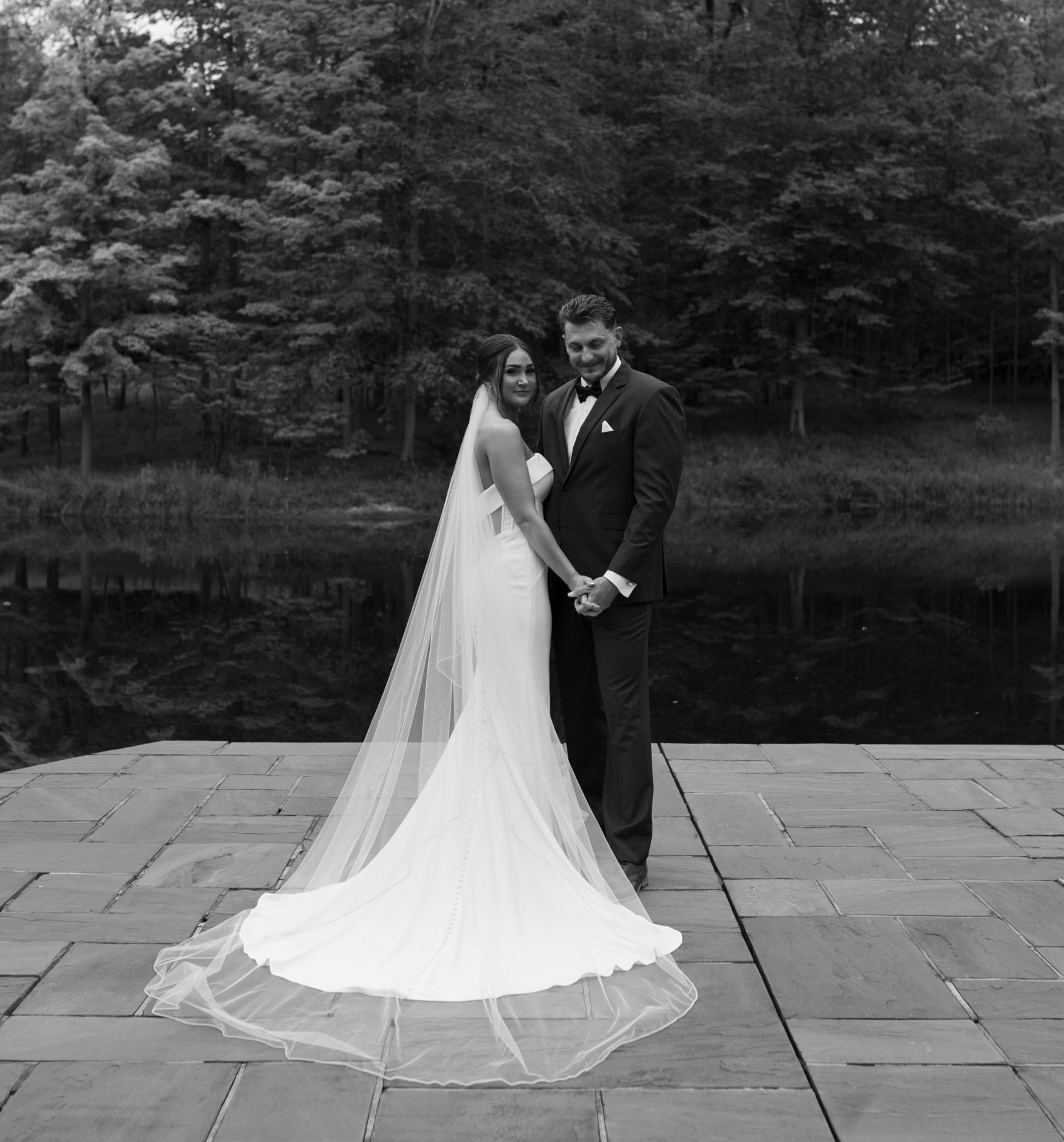 Bride and groom pose for couples portrait at their fine art wedding
