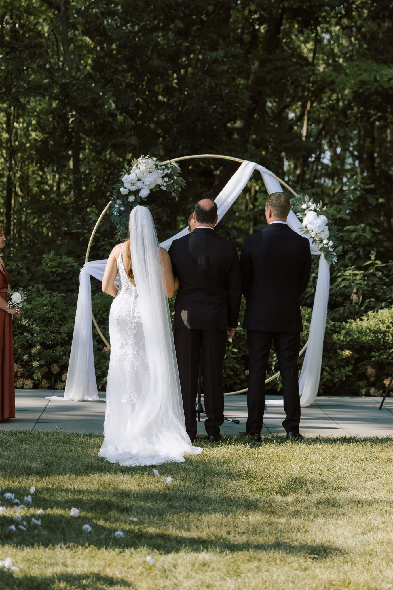 Couple meet at end of aisle with father of the bride